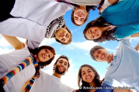 Das Bild zeigt junge Menschen, die sich an den Armen halten und von oben in die Kamera schauen.