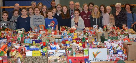 „Fröhliche Weihnachten für alle“: Uwe Hoffmann (hinten, elfter von links) und Landrat Manfred Müller (mittig im Bild) konnten gemeinsam mit den Schülerinnen und Schülern des St. Michael Gymnasiums und weiteren Helferinnen und Helfern der Tafel so viele Päckchen wie nie zuvor verteilen 