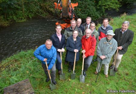 Spatenstich zur Renaturierung der Alme bei Ringelstein: 1. Reihe, von links: Dirk Nölting (Ortsvorsteher), Christian Hauschulte-Oberdick (Tiefbauunternehmer), Marianne Thomann-Stahl (Regierungspräsidentin), Landrat Manfred Müller, Prof. Winfried Stichmann (NRW-Stiftung), 2. Reihe von links: Hubertus Nolte (1. Vorsitzender GfN eV.), Volker Karthaus (WOL), Stefan Theis (Referatsleiter Liegenschaften NRW Stiftung), 3.Reihe von links: Karsten Schnell (Biologische Station Kreis PB), Franz Mattenklodt (GfN eV.), Ralf Kloke (Planungsbüro NZO GmbH) (Foto: Amt für Presse- und Öffentlichkeitsarbeit, Kreis Paderborn, Anna-Sophie Schindler)  Renaturierung der Alme
