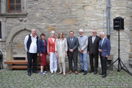 Auftakt nach Maß und very british: (von links nach rechts) Markus Moors, Wissenschaftlicher Mitarbeiter Kreismuseum Wewelsburg, Martina Wolf-Sedlatschek (stellvertretende Bürgermeisterin der Stadt Lichtenau, Kreistagsfraktion Die Grünen, Dr. Rita Winkelmann (Leihgeberin), Museumsleiterin Kirsten John-Stucke, Dr. Hauke Hendrik Kutscher vom LWL-Museumsamt, Dr. Rolf Mertens (Leihgeber), stellvertretende Landrat Vinzenz Heggen und der Verbindungsoffizier der britischen Streitkräfte Allan Patterson bei der Ausstellungseröffnung in der Wewelsburg Bildnachweis: Kreismuseum Wewelsburg