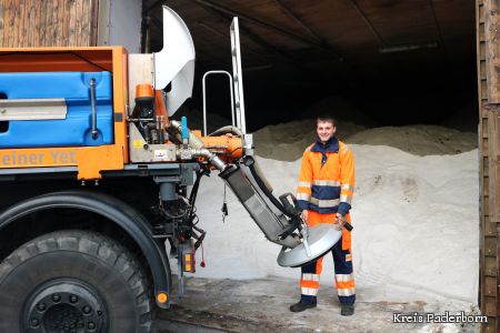 zu sehen ist Mitarbeiter Hendrik Schulte, der in einer großen Lagerhalle voller Salz den Streuwagen füllt