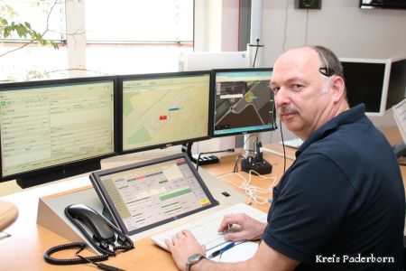 Wolfang Ceynowa sitzt an seinen Arbeitsplatz mit vier Monitoren