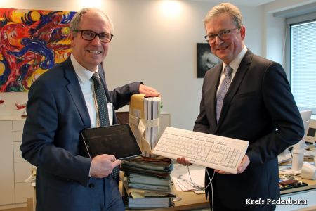Zu sehen sind Landrat Manfred Müller und Bürgermeister Michael Dreier mit einem großen Aktenberg.