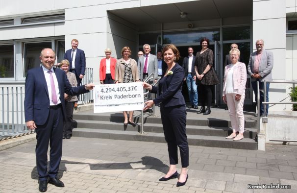 „Besser als in die Bildung und damit in die Zukunft der Kinder können wir das Geld nicht investieren“. NRW-Schulministerin Yvonne Gebauer (rechts im Bild) überreichte Landrat Christoph Rüther (links im Bild) im Beisein aller Schulleitungen der fünf Berufskollegs und drei Förderschulen in Trägerschaft des Kreises Paderborn einen symbolischen Scheck in Höhe von rund 4,3 Millionen Euro. Von links nach rechts: Ursula Wulff, Schulleiterin der Erich-Kästner-Schule, Franz-Josef Meyer, Schulleiter des Gregor-Mendel-Berufskollegs, Dezernentin Annette Mühlenhoff, Alexandra Hubenthal, Schulleiterin des Richard-von-Weizsäcker-Berufskollegs, Dr. Thomas Wassong, Leiter der IT Stabsstelle Kreis Paderborn, Matthias Groß, Leiter des Berufskollegs Schloß Neuhaus, Rainer Vidal, Bezirksregierung Detmold, Andreas Gelhaus, Leiter der Astrid-Lindgren-Schule, Schulausschussvorsitzende Silke Kohaupt, Andreas Czorny, Leiter des Helene-Weber-Berufskollegs, Christiane Menne, Leiterin des Ludwig-Erhard-Berufskollegs, Thomas Jujka, Schulleiter der Hermann-Schmidt-Schule