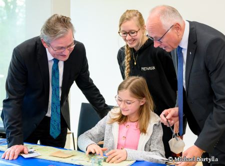 Bürgermeister Michael Dreier (links) und der stellv. Landrat Hans-Bernd Janzen staunen, was Kultur so möglich macht. Angelina Bienhüls vom Freiwerk zeigt, wie Saatbänder entstehen. © Michael Bartylla