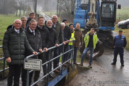 Eine Gruppe aus Personen, geben stehende auf einer Brücke den Startschuss für die Bauarbeiten