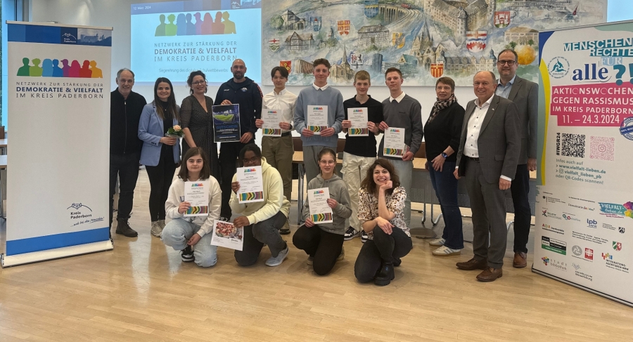 Herzlichen Glückwunsch nach Büren – Sechst- und NeuntklässlerInnen überzeugen beim ersten digitalen Schulwettbewerb zur Stärkung der Demokratie und Vielfalt im Kreis Paderborn - die Siegerinnen und Sieger mit (v.l.) Volker Kohlschmidt von Vielfalt lieben (DemokratieBüro Kreis Paderborn), Lehrerin Ricarda Korthoff, Christiane Hoffmann von der Regionalen Schulberatungsstelle (Systemberatung Extremismusprävention und Demokratieförderung), Benjamin Hüttemann vom SCP 07, Irmgard Rothkirch vom HNF, Landrat Christoph Rüther und Schulleiter Thorsten Harnischmacher