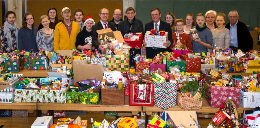 Verteilen Weihnachtspäckchen: Landrat Manfred Müller (6. Von links), Vorsitzender der Paderborner Tafel Uwe Hoffmann (7.von links), Bürgermeister Michael Dreier (8. Von links), die Ehrenamtlichen der Paderborner Tafel und die Schülerinnen und Schüler des Gymnasiums St. Michael. (Foto: Amt für Presse- und Öffentlichkeitsarbeit, Kreis Paderborn, Anna-Sophie Schindler)