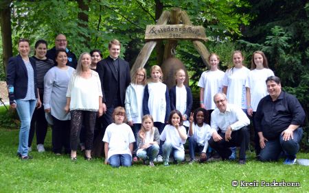Landrat und Schirmherr Manfred Müller (vordere Reihe, zweiter von links) und Gattin Elke Rawisch de Terán besuchten die Musical-Ferienfreizeit: Opern- und Konzertsängerin Petra Merschmann (dritte von links) und Gatte Volker Merschmann (ganz rechts im Bild) freuen sich mit den Kindern und Jugendlichen auf das Abschlusskonzert. Vikar Benedikt Kickum (siebter von links) hielt den Gottesdienst, den die Teilnehmer der Musical-Ferienfreizeit gestaltet haben. (Foto: Kreis Paderborn)