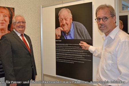 Fotograf Dr. Heinz-Peter Jost zeigt dem stellvertretenden Landrat Dr. Vinzenz Heggen seine Fotoausstellung „Delbrücker Lebensläufe – Spurensuche“. (Foto: Amt für Presse- und Öffentlichkeitsarbeit, Kreis Paderborn, Anna-Sophie Schindler)