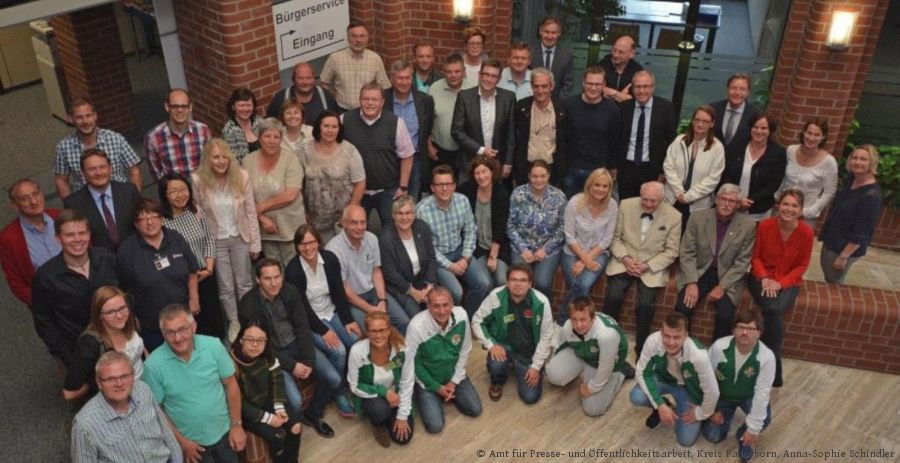 Vertretung  von 44 Vereinen und Institutionen kamen ins Hövelhofer Rathaus um den Kreisfamilientag Ende Mai Revue passieren zu lassen. Landrat Manfred Müller (2. Reihe von hinten, 6. von rechts) und Bürgermeister Michael Berens (letzte Reihe, 2. von rechts) lobten das breite Angebot und Engagement der Akteure. Die Federführung hatte das Paderborner Kreisjugendamt. Kreisjugendamtsleiter Günther Uhrmeister (2. Reihe von hinten, zweiter von links) und Organisatorin Edith Rehmann-Decker aus dem Kreisjugendamt (2. Reihe von vorne, ganz rechts), freuen sich über die durchweg positive Resonanz. (Foto: Amt für Presse- und Öffentlichkeitsarbeit, Kreis Paderborn, Anna-Sophie Schindler)  