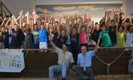 Sichtlich viel Spaß haben Kinder und Jugendliche im Padercamp: Landrat Manfred Müller, vorn, rechts im Bild, und Walter Preus (neben dem Landrat) vom Leitungsteam an Deck des großen Schiffes (Foto: Amt für Presse- und Öffentlichkeitsarbeit, Kreis Paderborn, Michaela Pitz)