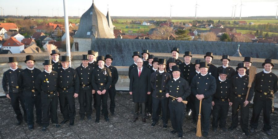 Schauen vom Nordturm der Wewelsburg über das Paderborner Land und wünschen allen Bürgern ein gesundes, glückliches und friedliches Jahr 2016: Die 26 Bezirksschornsteinfeger im Kreis Paderborn. (Foto: Kreis Paderborn, Herbert Temborius) 