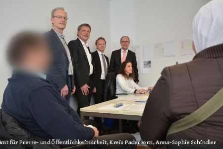 Betty Atlassi (sitzend) bearbeitet den Asylantrag von einem Flüchtlingsehepaar, dahinter, von links: Gerhard Kruse (Teamleiter der Ausländerbehörde), Horst-Hermann Müller (Geschäftsführer des Jobcenters), Volker Mäulen (Leiter der BAMF Außenstelle in Bielefeld) und Landrat Manfred Müller. (Foto: Amt für Presse- und Öffentlichkeitsarbeit, Kreis Paderborn, Anna-Sophie Schindler).  Betty Atlassi (sitzend) bearbeitet den Asylantrag von einem Flüchtlingsehepaar, dahinter, von links: Gerhard Kruse (Teamleiter der Ausländerbehörde), Horst-Hermann Müller (Geschäftsführer des Jobcenters), Volker Mäulen (Leiter der BAMF Außenstelle in Bielefeld) und Landrat Manfred Müller. (Foto: Amt für Presse- und Öffentlichkeitsarbeit, Kreis Paderborn, Anna-Sophie Schindler).