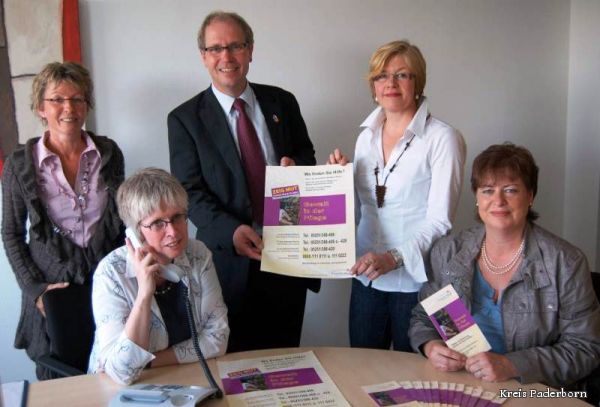 Landrat Manfred Müller präsentiert mit den Netzwerkpartnerinnen Kerstin Buchheldt (Kreisverwaltung), Monika Krieg (Telefonseelsorge), Martina Baumhoff-Jost (Caritasverband) und Claudia Schäfer (Kreisverwaltung) Plakate und Flyer, die auf das Pflege-Kummer-Telefon hinweisen. Nicht im Bild: Dietmar Steinke (Seniorenbüro der Stadt Paderborn).